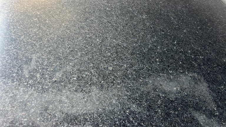 Close-up of frost or ice crystals covering a dark textured surface