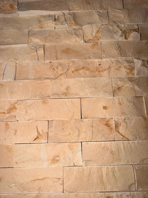 Beige tile floor with rectangular tiles arranged in staggered horizontal rows, showing natural stone texture and veining