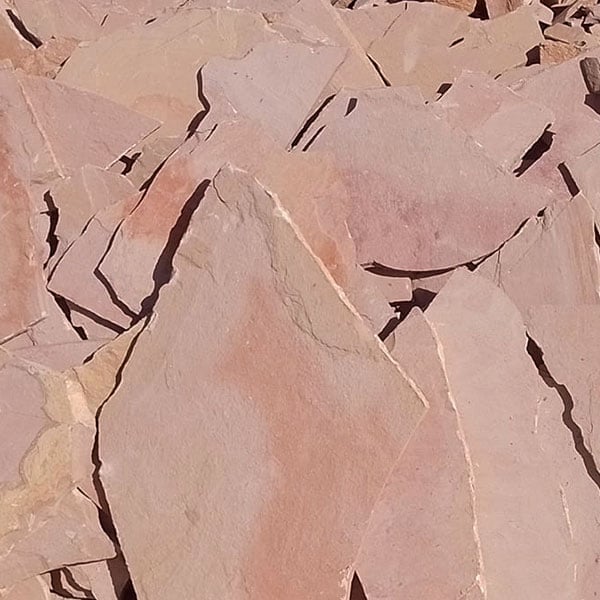 Aerial view of cracked, parched earth with geometric fracture patterns in pink and beige tones