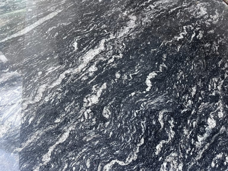Aerial view of dark ocean water with white wave patterns and foam creating ripples and swirls across the surface
